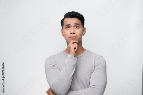 Studio shot of young handsome Asian man against white background photo