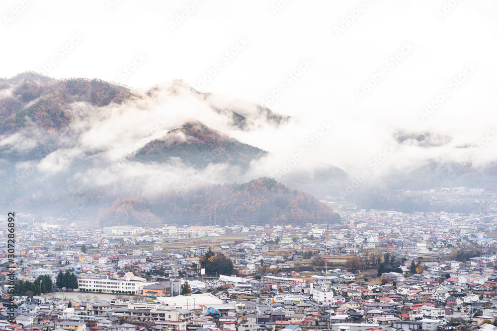 Obraz premium small town near the mountain with mist cover in the morning