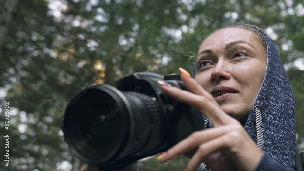 Traveler photographing scenic view in forest. One caucasian woman shooting close up look. Girl take photo video on dslr mirrorless camera. Professional photographer travel with backpack. Outdoor. Traveler photographing scenic view in forest. One caucasian woman shooting close up look. Girl take photo video on dslr mirrorless camera. Professional photographer travel with backpack. Outdoor.