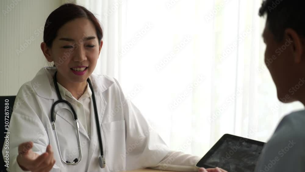 Asian doctor and patient are discussing something Asian doctor and patient are discussing something