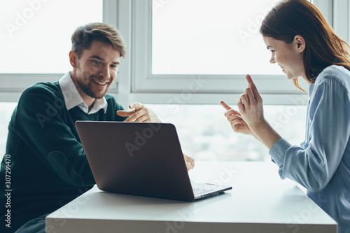 man and woman working on laptop in office