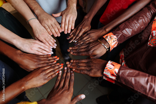 Hands of happy group of multinational African, latin american and european people which stay together in circle