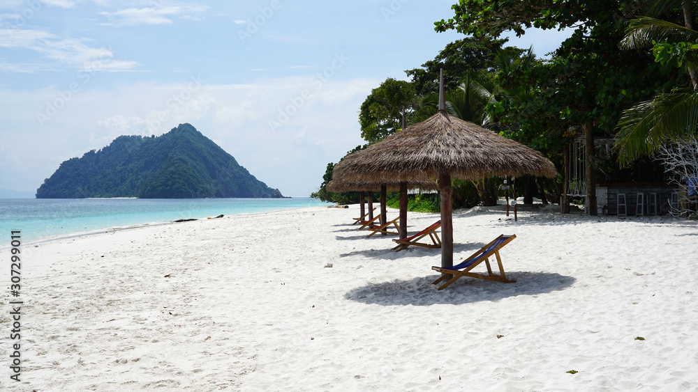 Fototapeta premium Natural leaves tropical parasol on the beach with blue sea background outdoor