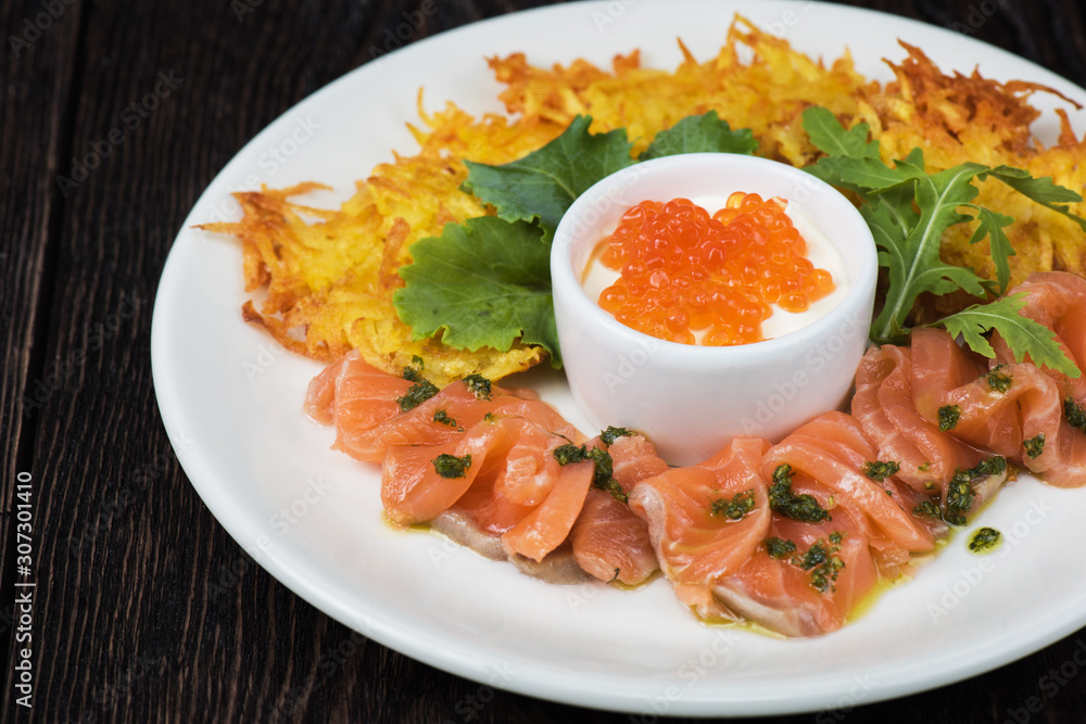 Plate with potato pancakes salmon fish and red caviar Plate with potato pancakes salmon fish and red caviar