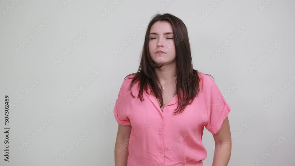 Caucasian shocked young woman in pink shirt keeping hand on head, covering mouth with hands isolated on white background in studio. People sincere emotions, lifestyle concept. Caucasian shocked young woman in pink shirt keeping hand on head, covering mouth with hands isolated on white background in studio. People sincere emotions, lifestyle concept.