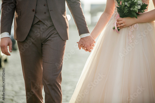Фотография close up. bride and groom walking together.