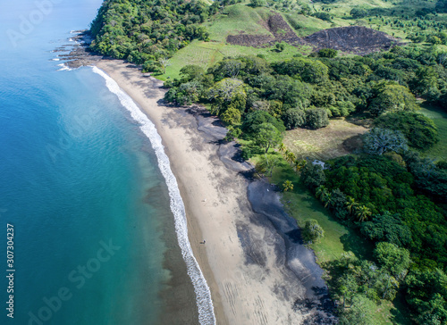 Aerial shot of wedding dress couple on the tropical beach Playa Arenillas in Costa Rica with a heart drawn into Sand