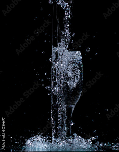 splash and spatter of water in a wine glass on a black background