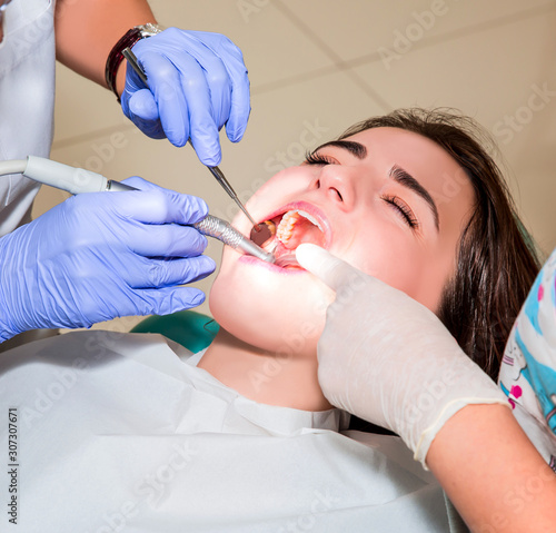 Dentist and his assistant carrying out a thorough examination  real treatment 