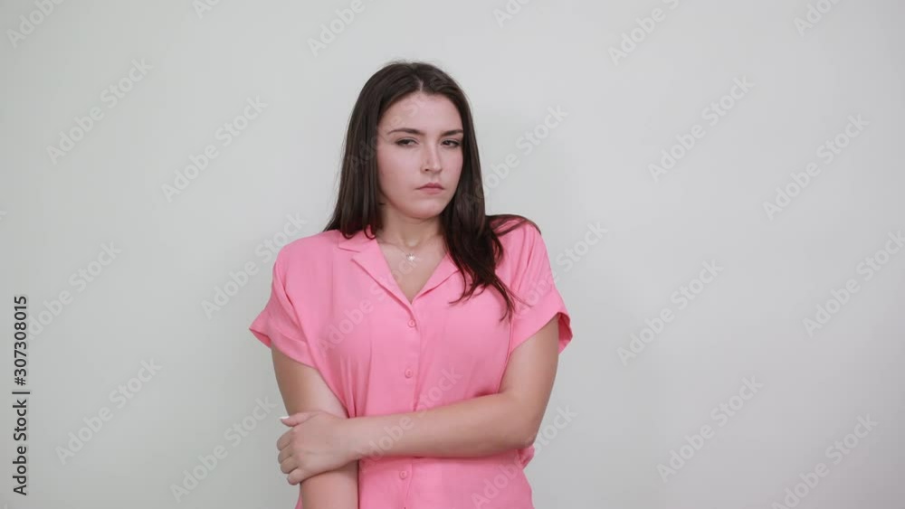 Shocked caucasian young woman in pink shirt keeping hands on mouth, looking scared isolated on white background in studio. People sincere emotions, lifestyle concept. Shocked caucasian young woman in pink shirt keeping hands on mouth, looking scared isolated on white background in studio. People sincere emotions, lifestyle concept.