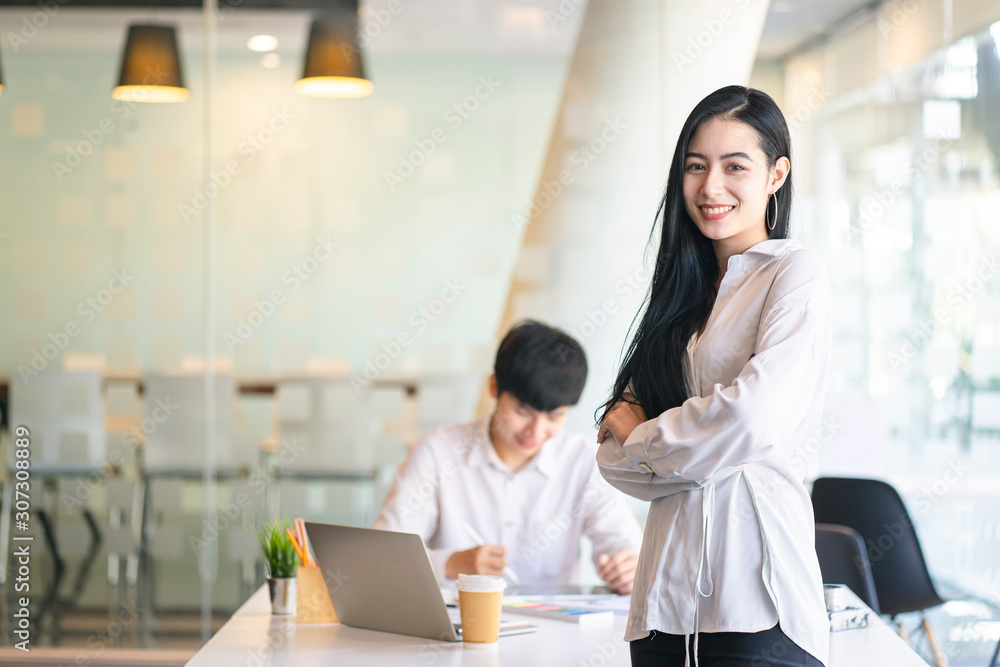 Asian confident business woman arms crossed in the working space. Portrait of young entrepreneur woman with white casual shirt. Asian confident business woman arms crossed in the working space. Portrait of young entrepreneur woman with white casual shirt.