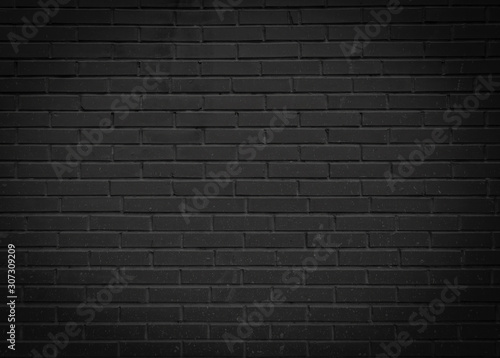 Black brick wall. Gloomy abstract background for design. The texture of the brick surface.
