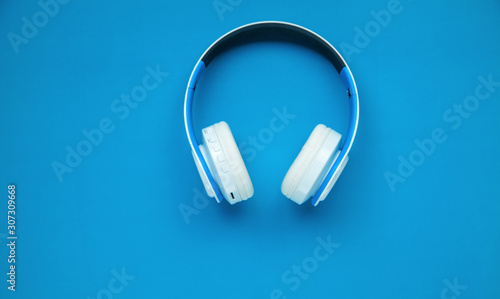 White wireless headphones on the blue background.