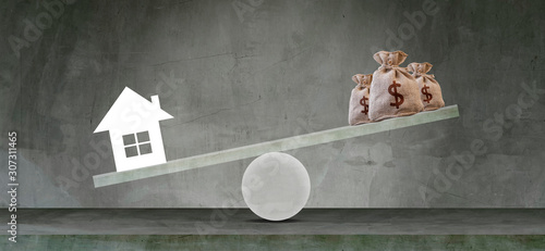 Housing loan market Sample houses and balance piggy bank on the seesaw Real estate concepts,Personal income imbalance.