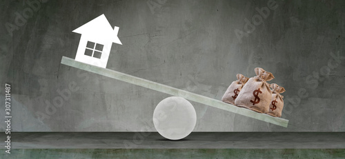 Housing loan market Sample houses and balance piggy bank on the seesaw Real estate concepts,Personal income imbalance.