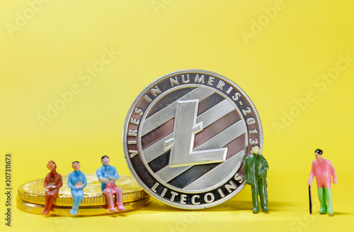 Miniature people: A small businessman sitting on a Litecoin coin, Financial, Business Growth concept. 