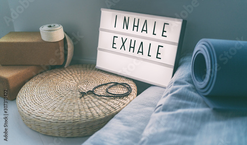 Fotografie, Obraz Yoga breathing INHALE EXHALE sign at fitness class on lightbox inspirational message with exercise mat, mala beads, meditation pillow