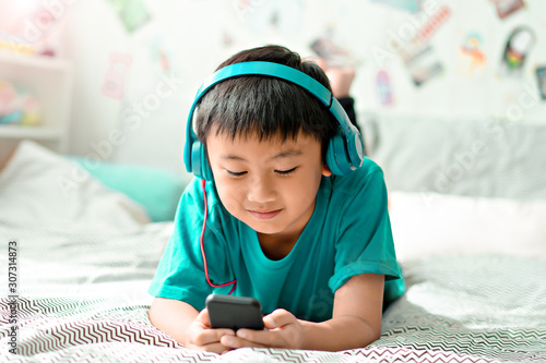 Kid listening to music on bed at bedroom for relax