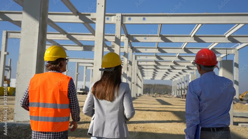 Construction Business Team Walking on Building Site. Business, Building, Teamwork and People Concept. Project Management and Field Crew Meeting on Construction Site.
