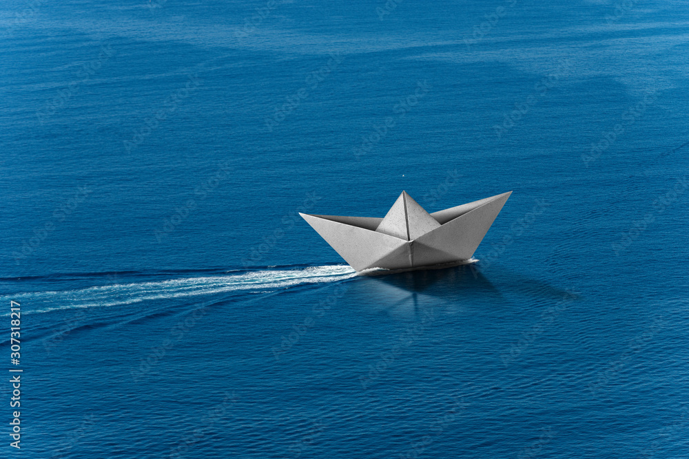 White paper boat runs fast over the blue sea with wake, photography aerial view