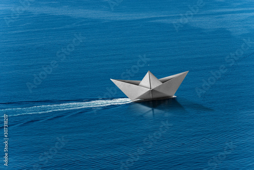 White paper boat runs fast over the blue sea with wake  photography aerial view