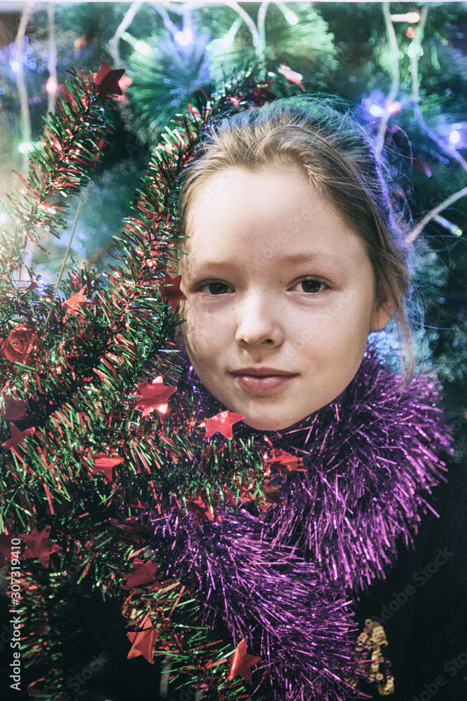 Girl with Christmas garland, face close-up Girl with Christmas garland, face close-up