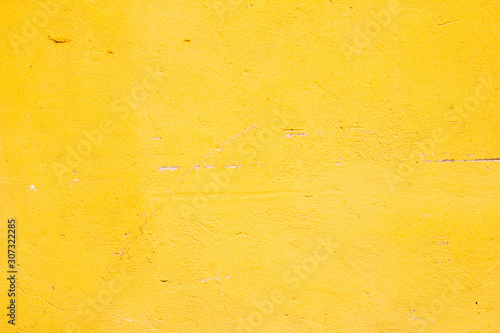plastered old wall painted yellow textured paint with scratches and damage