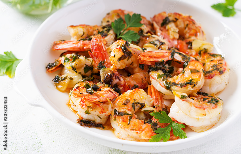 Grilled shrimps. King prawn tails in orange-garlic sauce with parsley. Grilled shrimps. King prawn tails in orange-garlic sauce with parsley.