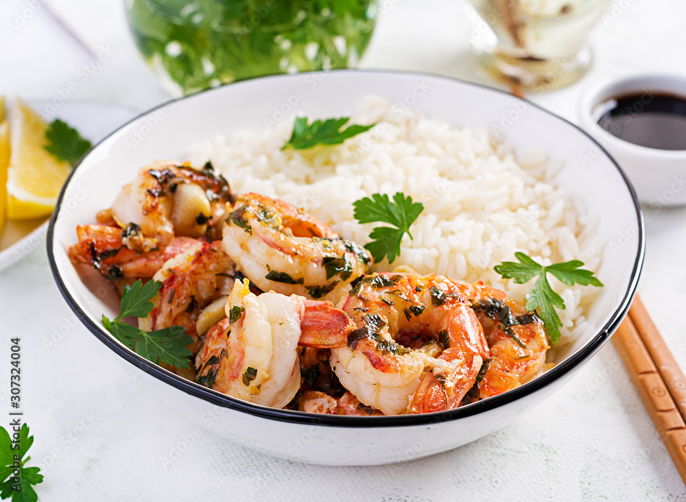 Grilled shrimps and boiled rice. King prawn tails in orange-garlic sauce with parsley. Grilled shrimps and boiled rice. King prawn tails in orange-garlic sauce with parsley.