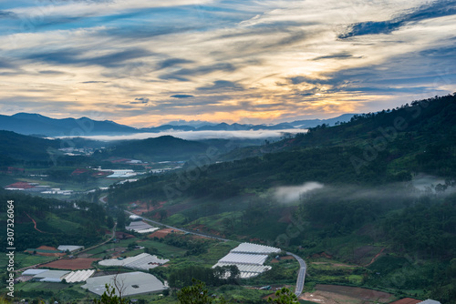 Orange overcast sky at dusk and misty valley scenery