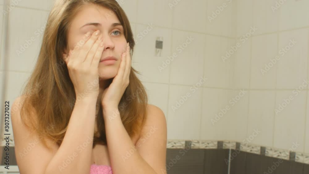 young woman in the bathroom preens and doing makeup, girl in morning routine, concept cosmetics and female beauty young woman in the bathroom preens and doing makeup, girl in morning routine, concept cosmetics and female beauty
