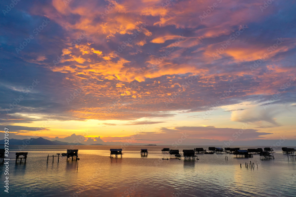 Aerial view of Sea Gypsy water village, island and the ocean with sky during sunrise in Semporna, Sabah, Malaysia, Borneo. Aerial view of Sea Gypsy water village, island and the ocean with sky during sunrise in Semporna, Sabah, Malaysia, Borneo.
