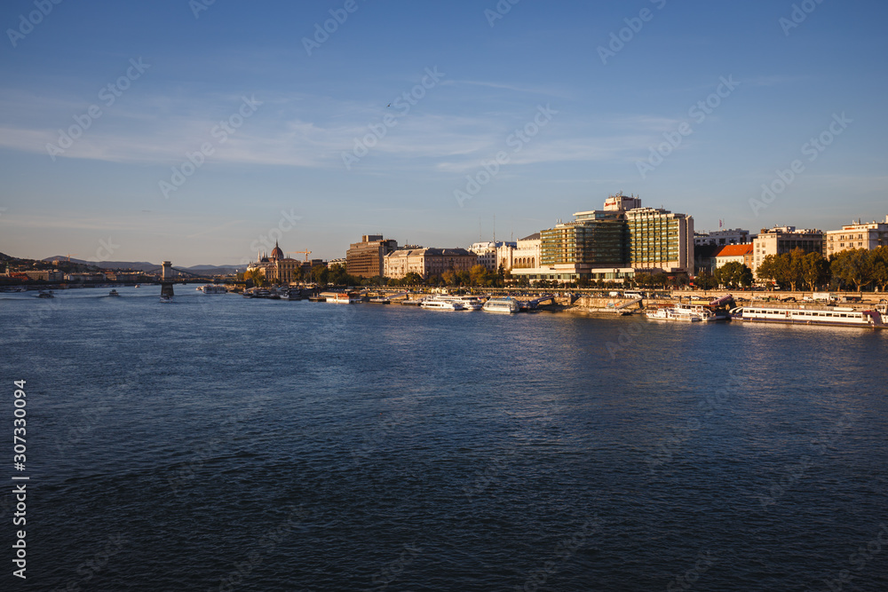 Landscapes of the buildings and harbor with boats beside Danube River in Budapest