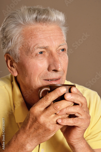 Close up portrait of senior man drinking cup of coffee