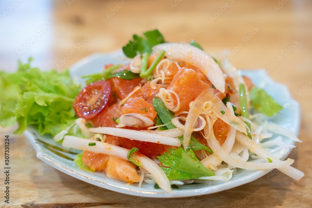 spicy mixed salad on wooden table. spicy mixed salad on wooden table.