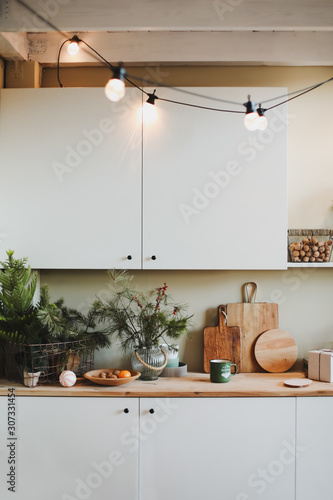 Festive kitchen in Christmas decorations. Christmas dining room. Beautiful New Year decorated classic home interior. New Year and Christmas background