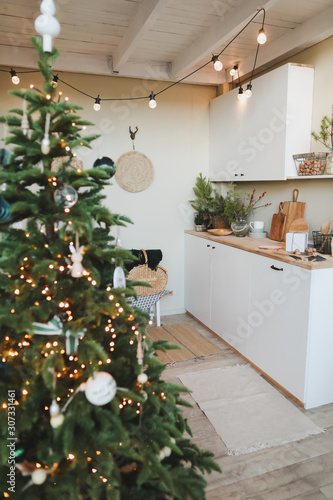 Festive kitchen in Christmas decorations. Christmas dining room. Beautiful New Year decorated classic home interior. New Year and Christmas background