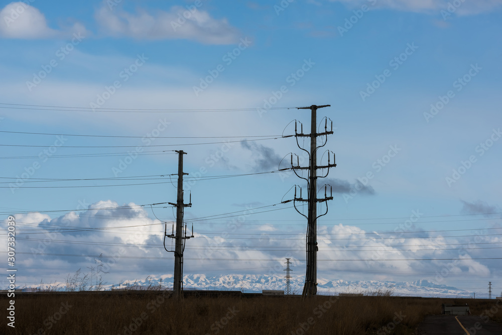High voltage pylons on dry grassland