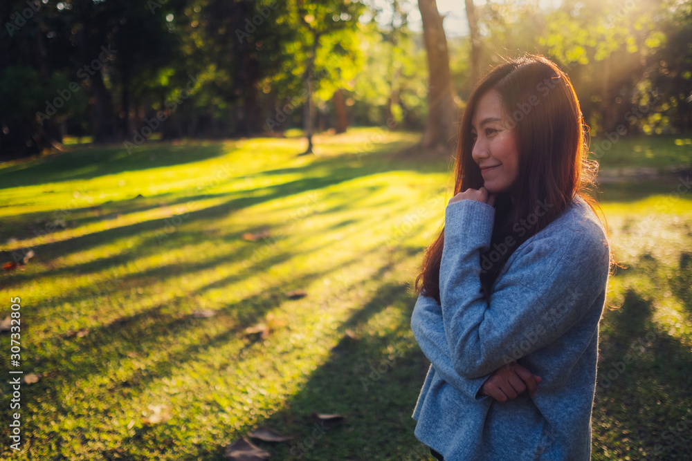 Portrait image of a beautiful asian woman standing among nature in the park before sunset Portrait image of a beautiful asian woman standing among nature in the park before sunset