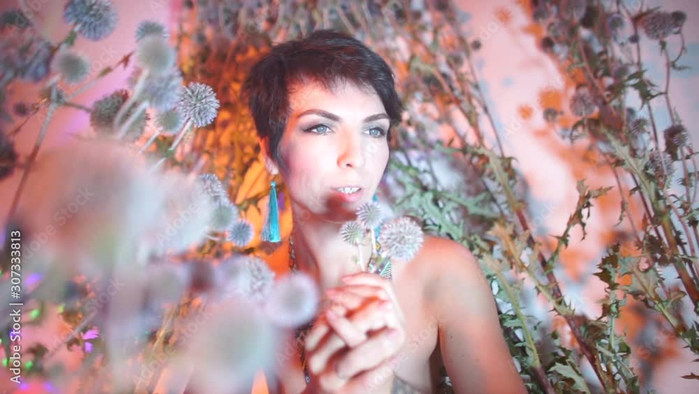 Female magician holds flowers in his hands and makes dance moves. Female magician holds flowers in his hands and makes dance moves.