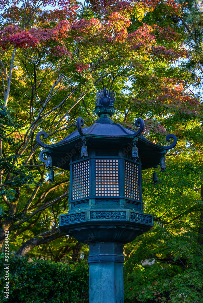 Japanese stone lantern at autumn garden