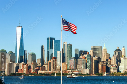 Panorama of the skyline of Manhattan with the American flag in the middle. One world trade center towering over the rest of the buildings. New York, USA.