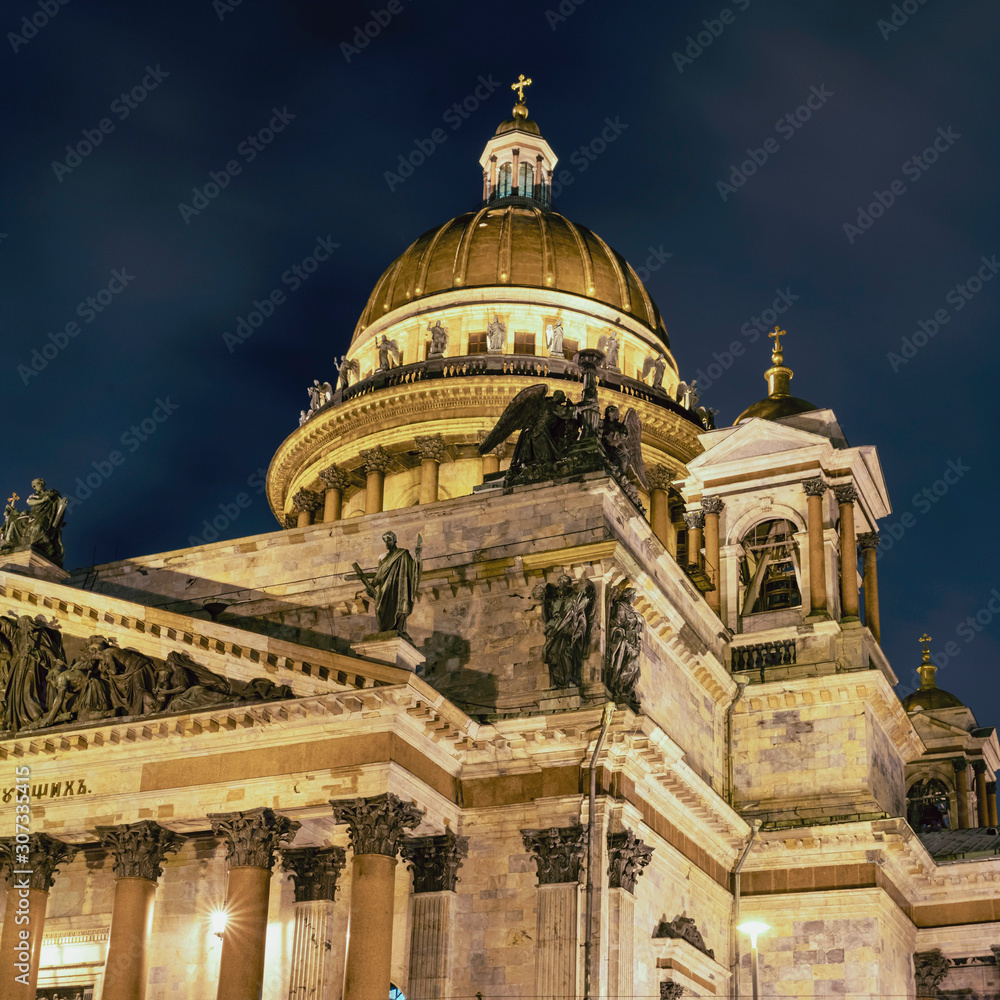 facade of St. Isaac's Cathedral in the rays of light against the night sky in St. Petersburg, Russia