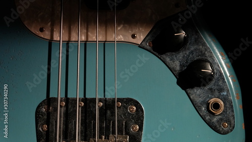 Closeup of Blue Guitar Bass and light coming through on Body Relic with selective focus.