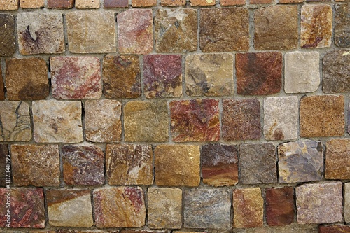 Background. Stones of different colors on the wall. Square cheese shape.