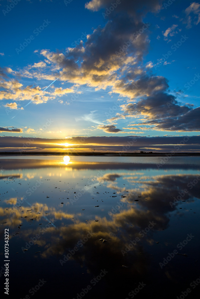 Dramatic mirror reflection of sunset and clouds in the still waters os Lake Tyrrell, a salt lake in north west Victoria, Australia.
