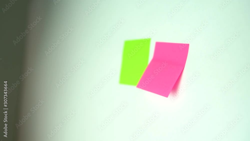 Man hand post colorful sticky note on white board Man hand post colorful sticky note on white board