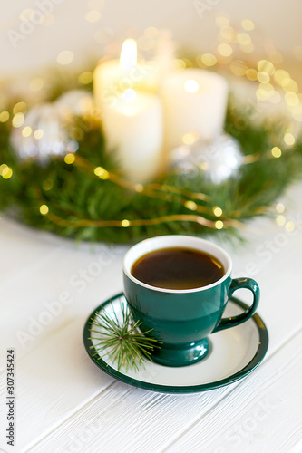 Cup of coffee on a background of Christmas decor. Advent candles