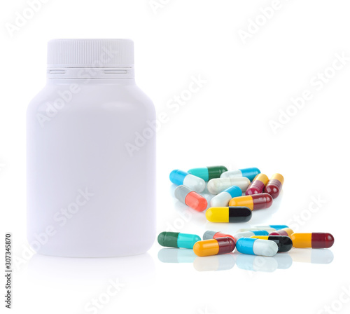 White plastic medicine bottle and medical capsules on white background.