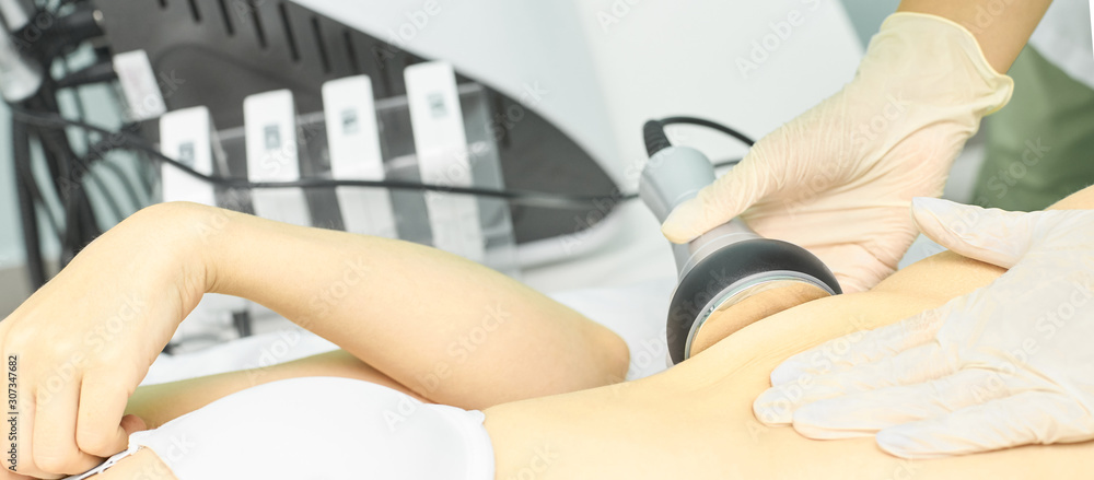 Fototapeta premium Cavitation rf body treatment. Female ultra sound lipo machine. Spa contouring. Doctor hands